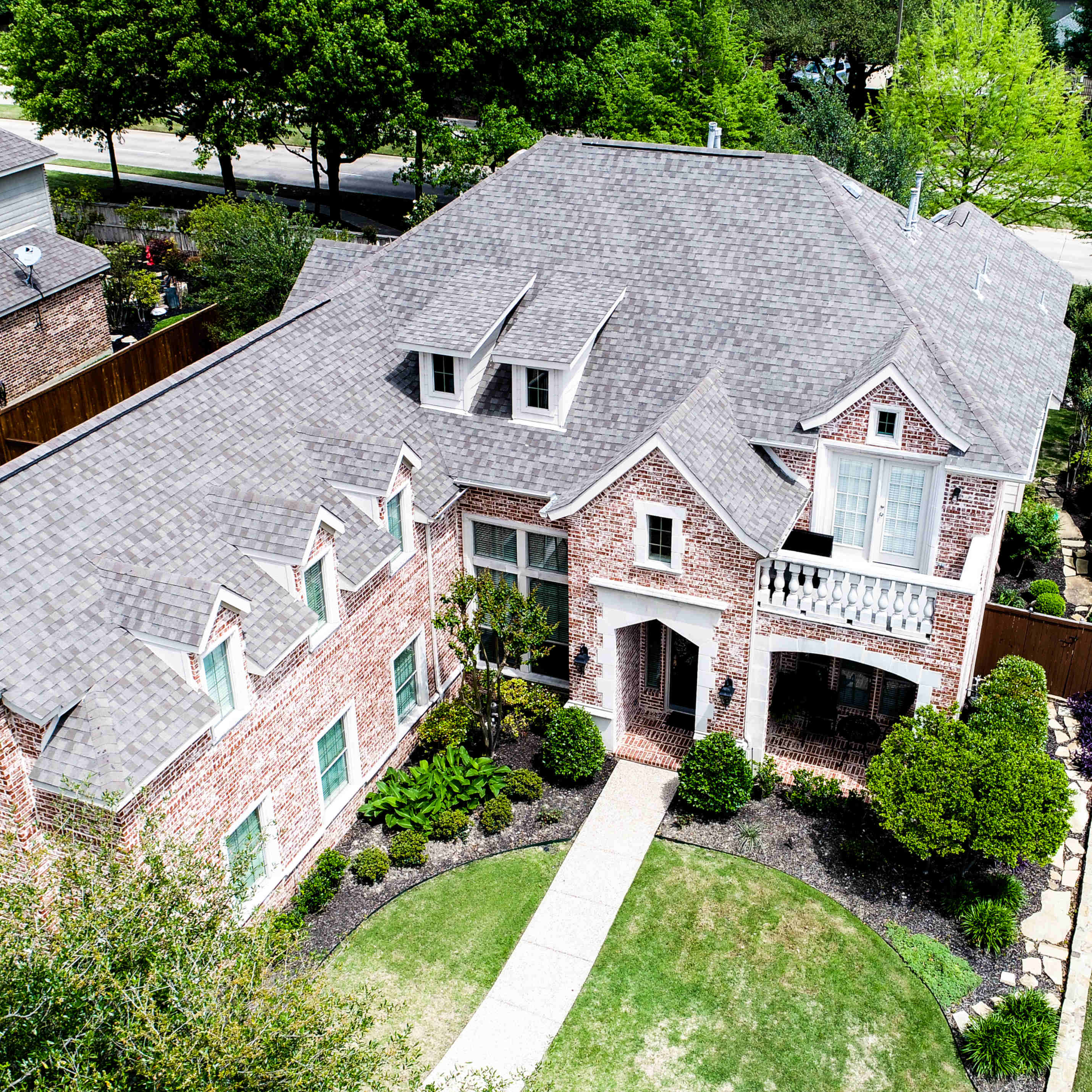 Aerial view of a completed Heritage shingle roof on a Texas brick home